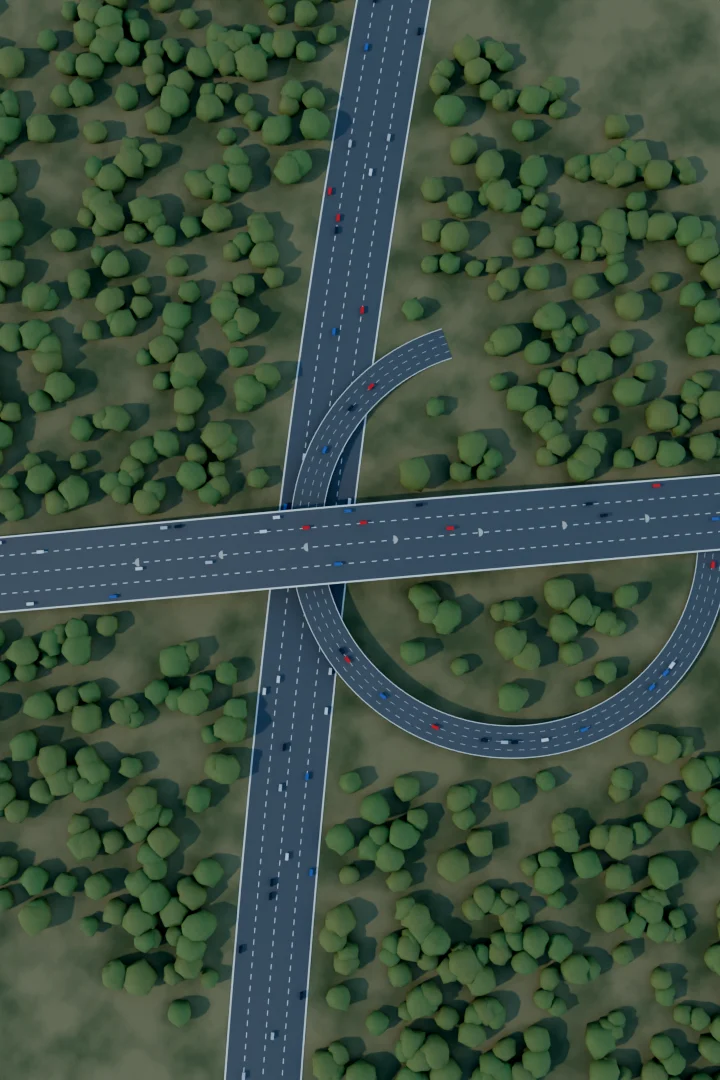 Top-down view of a highway interchange with an elevated crossing surrounded by forest