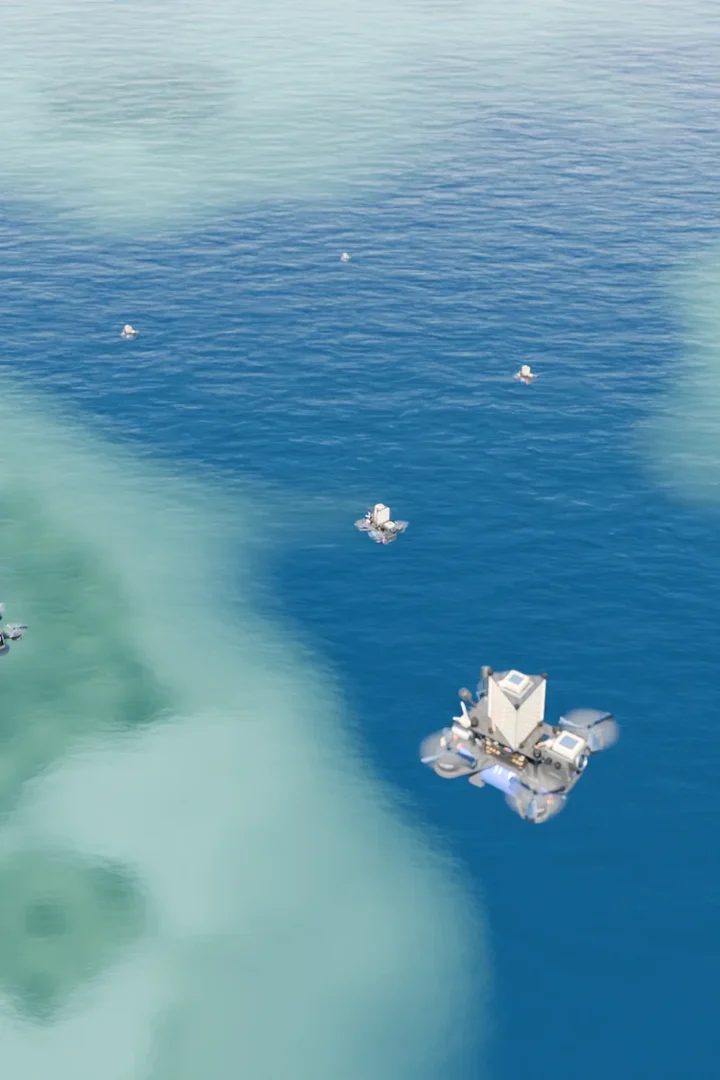 AERKI drones flying low over a coral reef in clear turquoise water